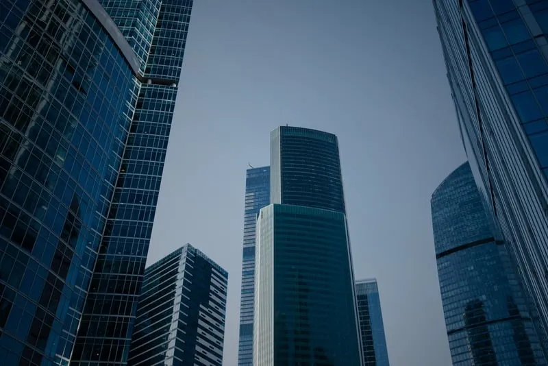Glass office towers against a blue sky.