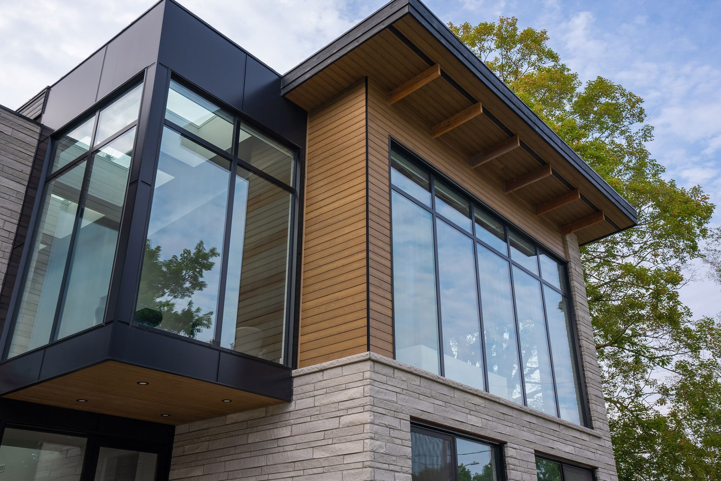 Two-storey glazed corner beneath a cedar soffit at 41 Alice Street.